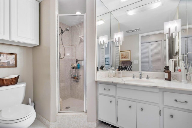 full bath featuring toilet, a stall shower, vanity, and baseboards