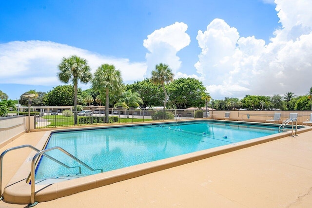 community pool with a patio and fence