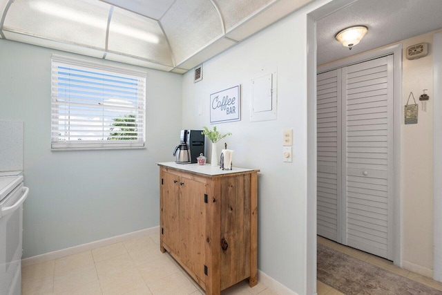 kitchen featuring light tile patterned floors, visible vents, light countertops, and baseboards