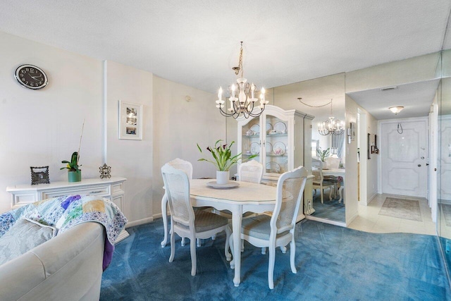 carpeted dining area featuring a textured ceiling, baseboards, and a chandelier