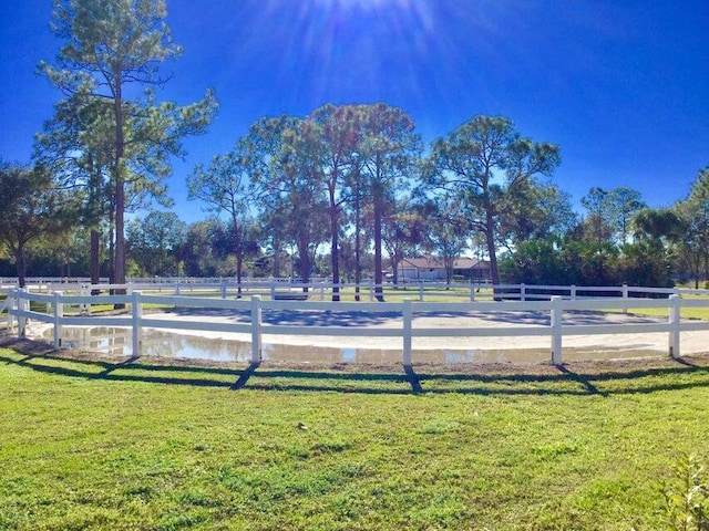 view of community with a yard and fence