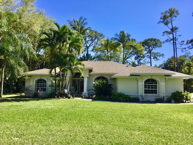 view of front of house featuring stucco siding and a front lawn