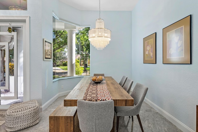 dining room featuring an inviting chandelier and baseboards