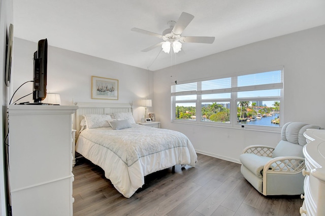 bedroom with baseboards, ceiling fan, and wood finished floors