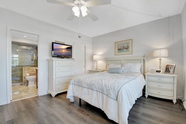 bedroom with dark wood finished floors, a ceiling fan, and connected bathroom