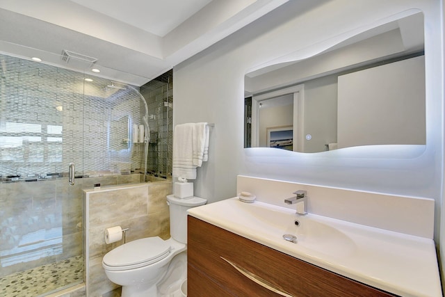 bathroom with vanity, toilet, visible vents, and a stall shower