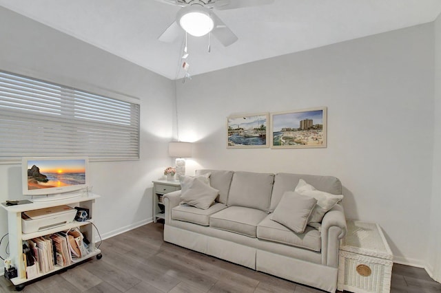 living area featuring wood finished floors, a ceiling fan, and baseboards