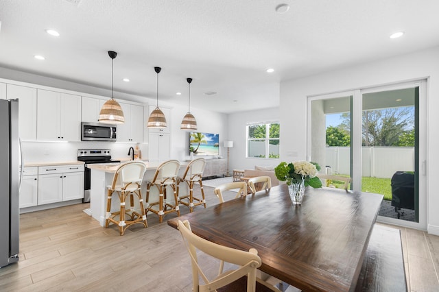 dining room with recessed lighting and light wood-type flooring