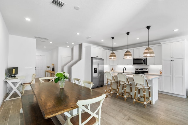 dining area with recessed lighting, visible vents, and light wood finished floors