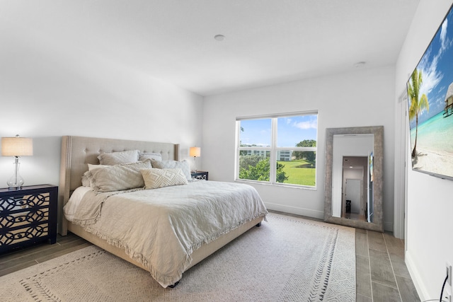 bedroom with baseboards and wood tiled floor