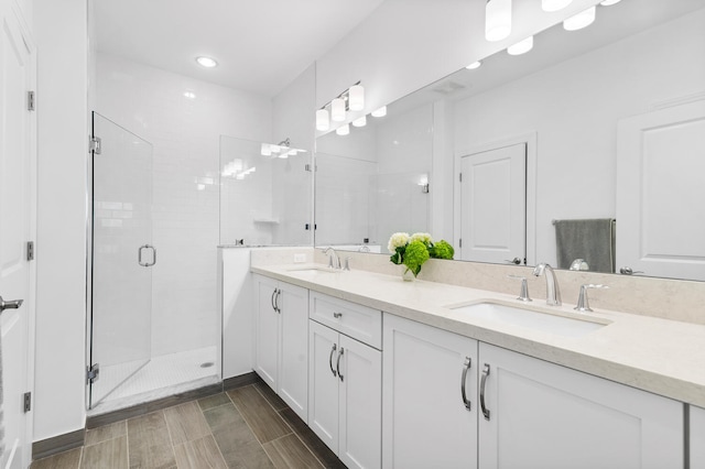 full bathroom featuring a shower stall, double vanity, and a sink