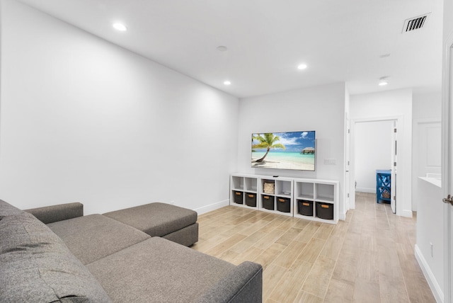 living room with light wood finished floors, visible vents, recessed lighting, and baseboards