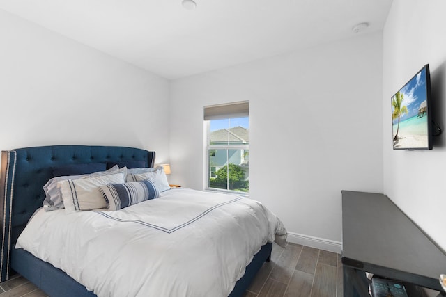 bedroom featuring baseboards and wood finish floors