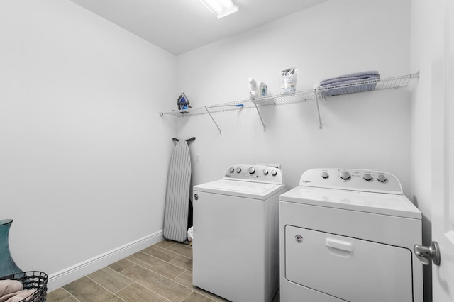 laundry room featuring washer and dryer, laundry area, baseboards, and wood tiled floor