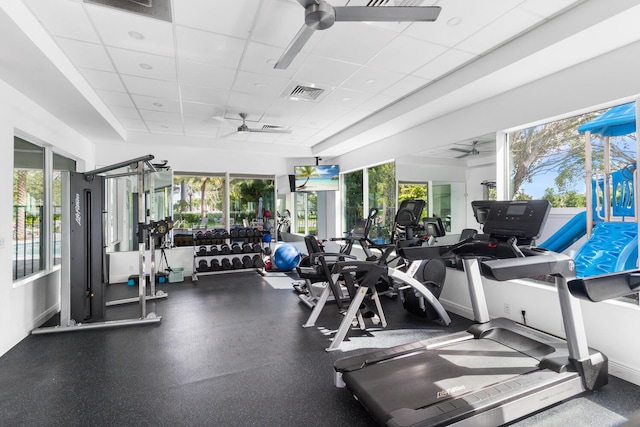 workout area with visible vents, a paneled ceiling, baseboards, and ceiling fan