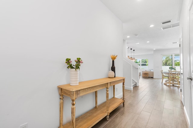 hallway with stairway, recessed lighting, visible vents, and baseboards