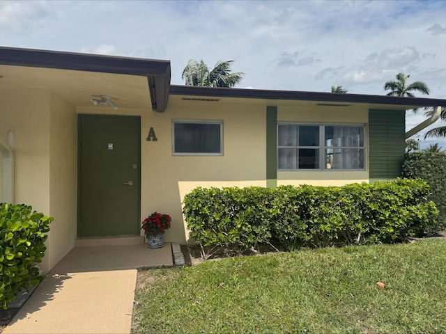 entrance to property featuring stucco siding