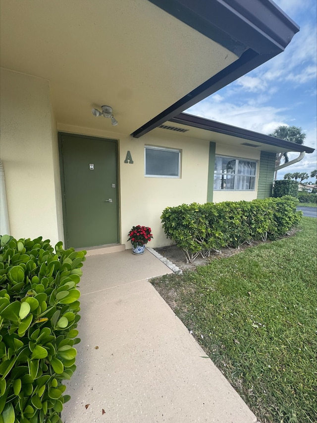 property entrance with stucco siding