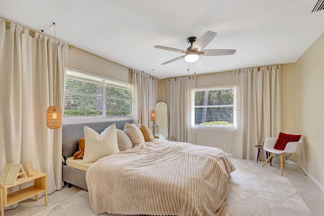 bedroom with light tile patterned floors, baseboards, visible vents, and ceiling fan