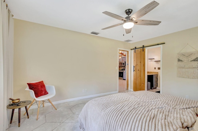 bedroom featuring light tile patterned floors, a ceiling fan, baseboards, visible vents, and a barn door