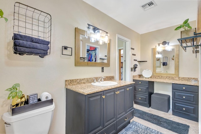 bathroom featuring visible vents, toilet, and vanity