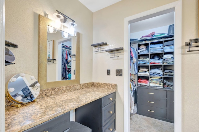 bathroom featuring vanity and a spacious closet