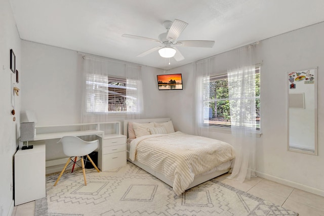 bedroom featuring light tile patterned flooring, a ceiling fan, baseboards, and built in study area