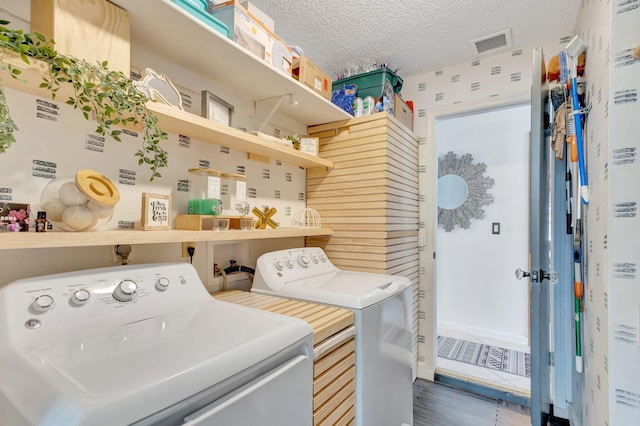 laundry area featuring washer and clothes dryer, laundry area, a textured ceiling, and visible vents