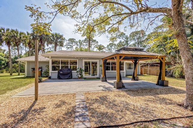 rear view of property with a yard, a gazebo, and a patio