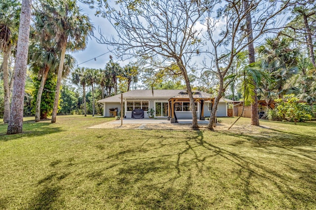 rear view of property with a patio and a lawn