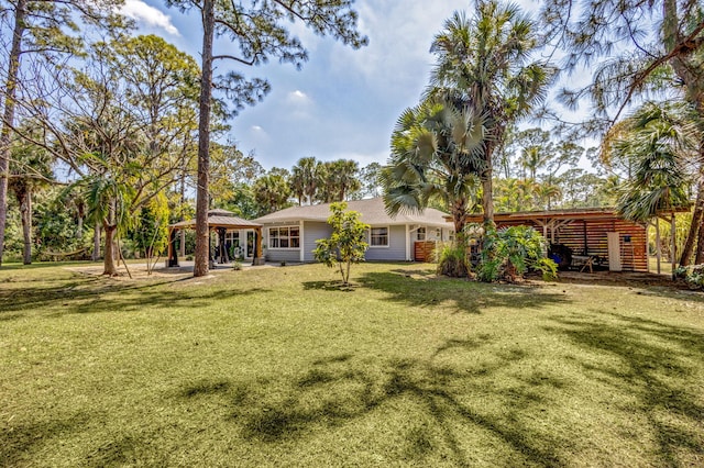 back of house with a gazebo and a lawn