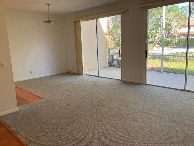 unfurnished living room with carpet flooring and baseboards