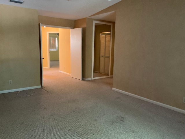 carpeted spare room with visible vents and baseboards