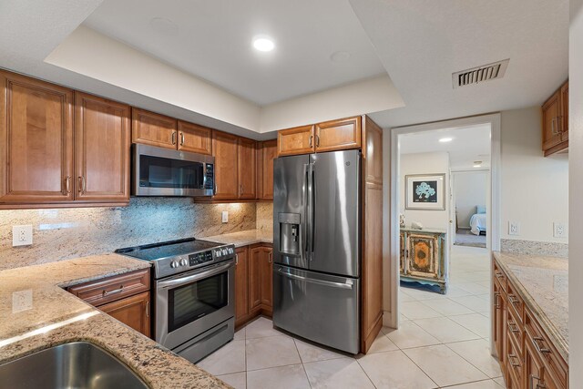 full bathroom with a spacious closet, tile patterned floors, and a sink