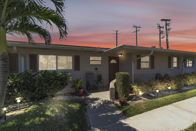 ranch-style home featuring stucco siding