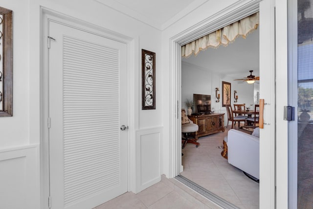 hallway featuring crown molding and light tile patterned flooring