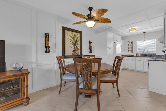 dining room featuring light tile patterned flooring, a decorative wall, and a ceiling fan