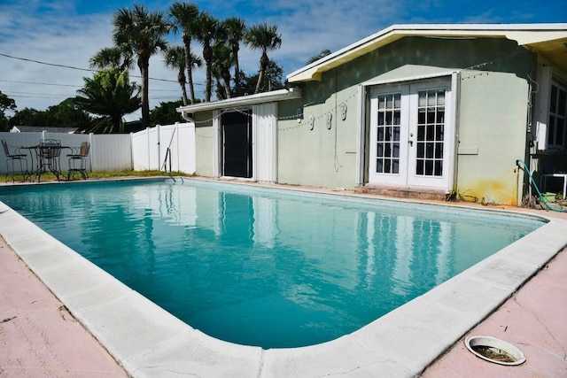 view of swimming pool with fence, french doors, and a fenced in pool