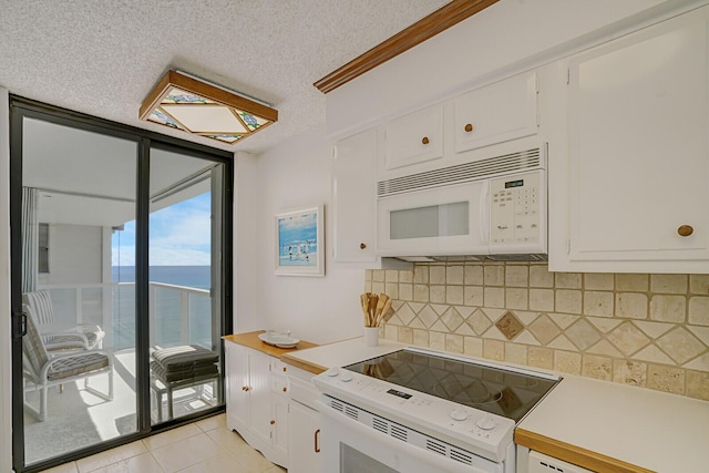 kitchen with floor to ceiling windows, light countertops, decorative backsplash, white cabinets, and white appliances