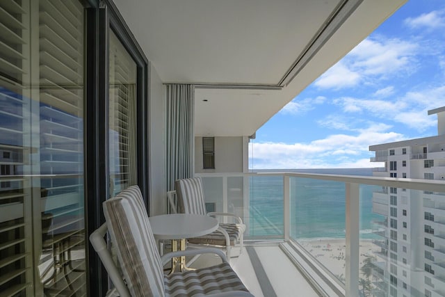 balcony featuring a water view and a view of the beach