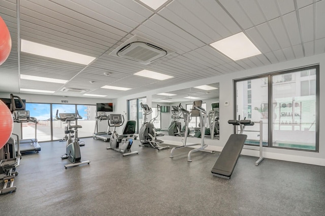 gym with visible vents, a paneled ceiling, and baseboards