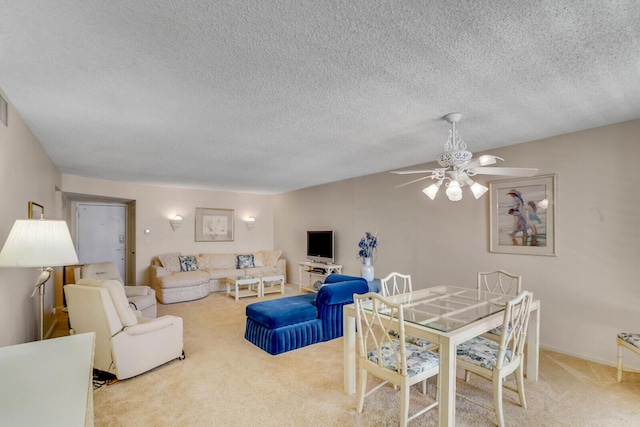 living area with carpet floors, a textured ceiling, and a ceiling fan