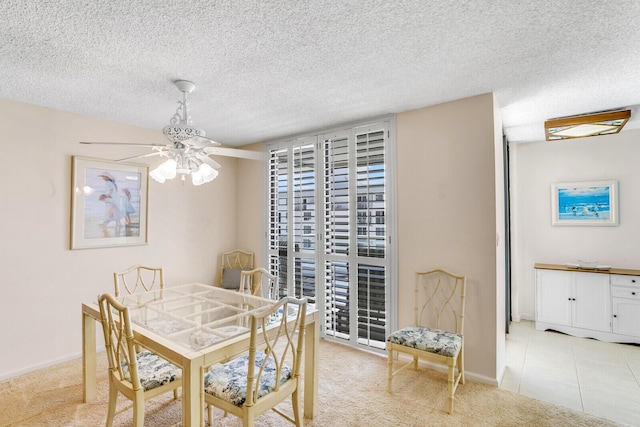 dining room with baseboards, ceiling fan, a textured ceiling, and carpet