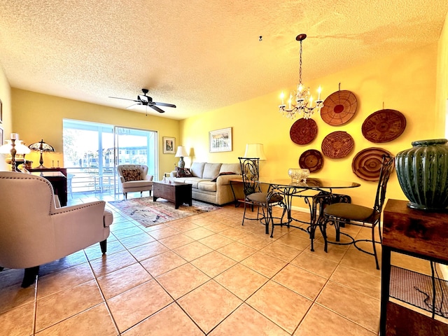 living room with light tile patterned flooring, ceiling fan with notable chandelier, and a textured ceiling