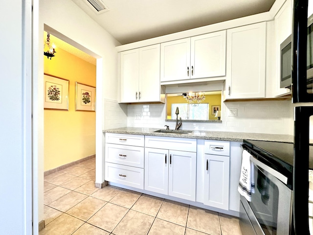 kitchen with a chandelier, white cabinetry, and a sink