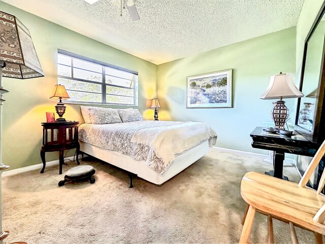 bedroom featuring baseboards, carpet floors, a textured ceiling, and a ceiling fan