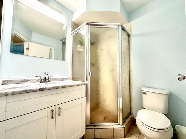 bathroom featuring vanity, tile patterned floors, toilet, and a stall shower