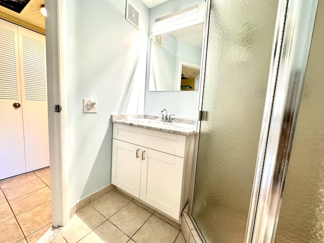 bathroom featuring visible vents, a shower stall, baseboards, tile patterned floors, and vanity