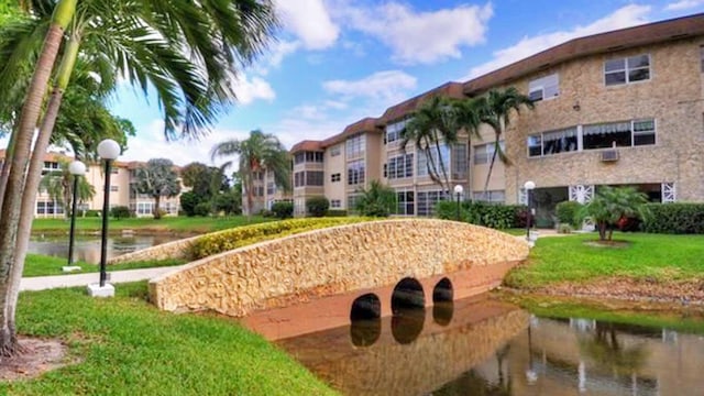 surrounding community featuring a lawn and a water view