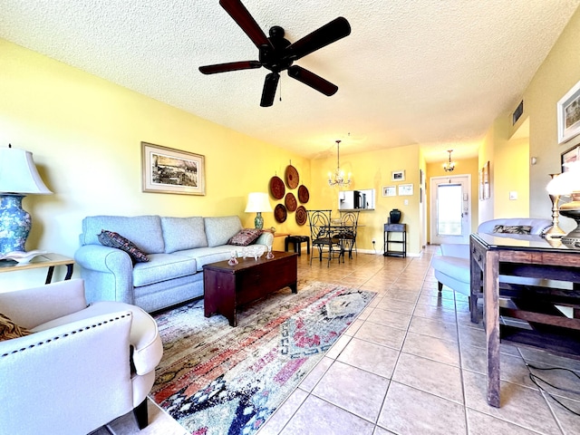 living room with visible vents, a textured ceiling, light tile patterned flooring, and ceiling fan with notable chandelier